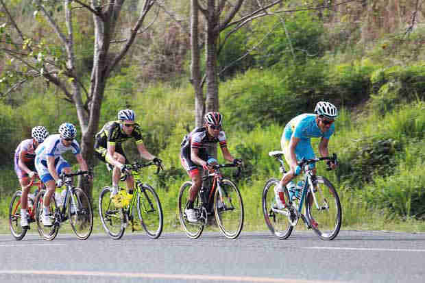 Cyclists negotiate an uphill road during the cycling tour 2015 edition.